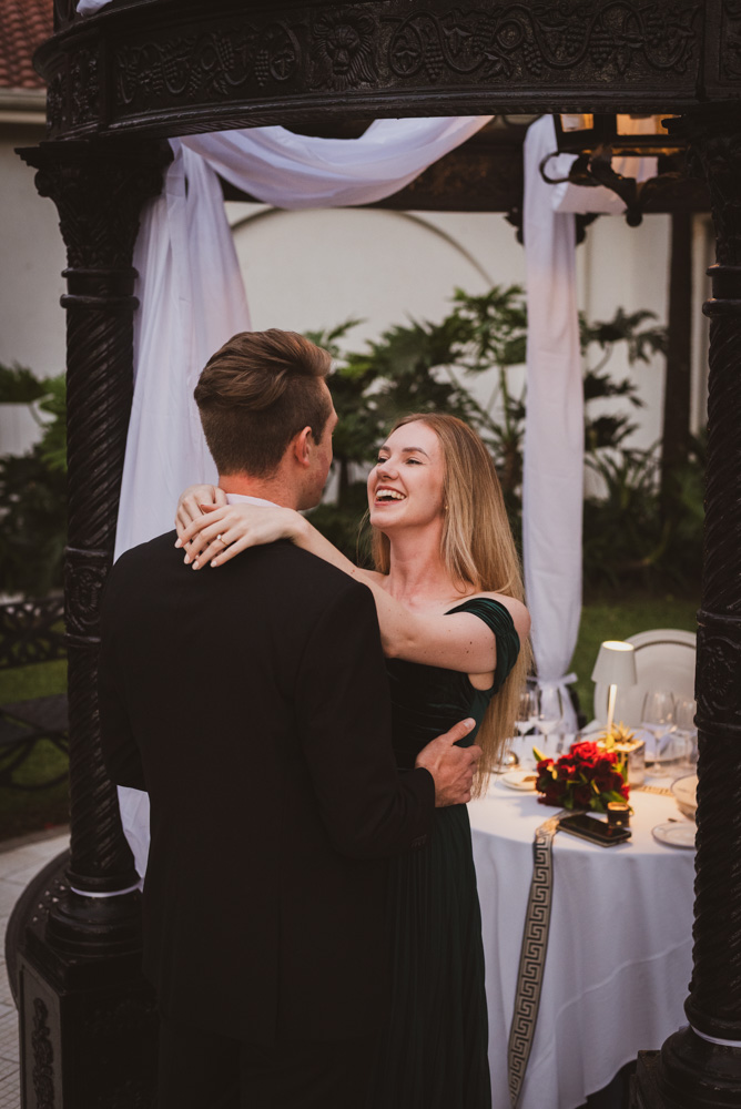 Woman staring into Fiancé's eyes in Love and with a Joyful Expression. The couple are wearing evening wear and the image is taken at the Oyster Box Hotel in Umhlanga